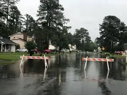 Flooded neighborhood street closed with barricades after a storm